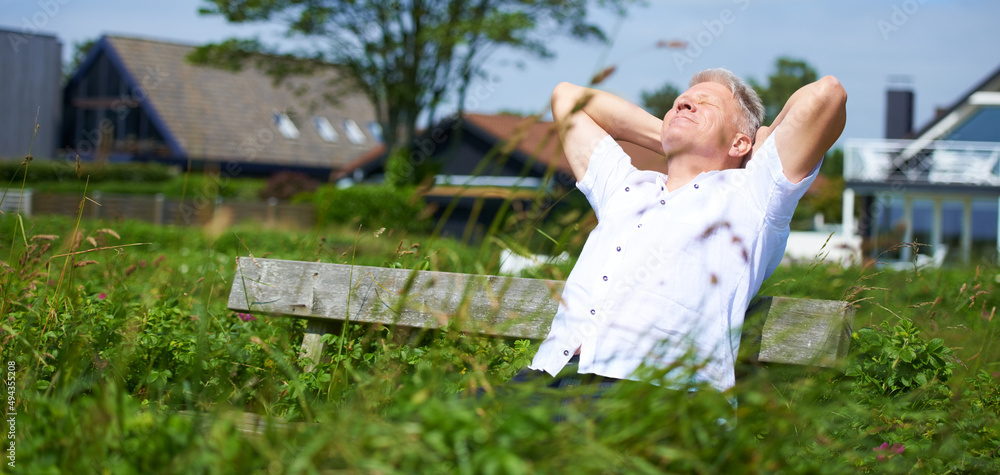 Reveling in nature. A senior man relaxing on a park bench. Reveling in nature. A senior man relaxing on a park bench.