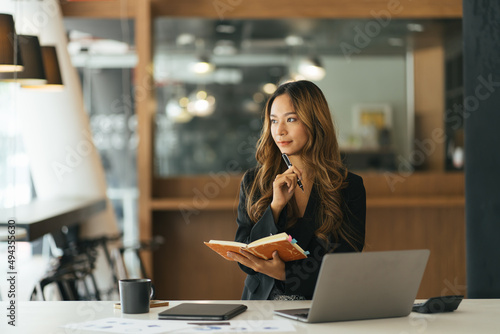 Business asian woman taking note on note book, Attractive girl working with laptop computer