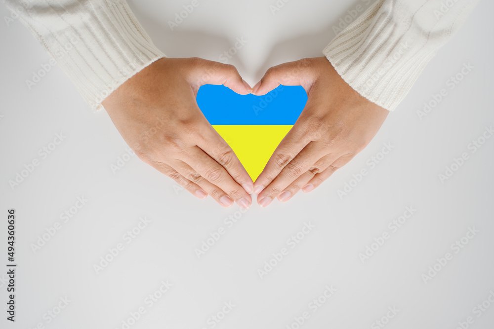 Save Ukraine no more war in the concept of woman hand and the flag in heart shape. The patriotism and protect the people of Ukraine. Save Ukraine no more war in the concept of woman hand and the flag in heart shape. The patriotism and protect the people of Ukraine.