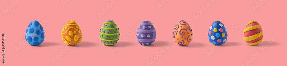 Easter greeting card with aligned and centered easter eggs design. Handmade from plasticine on a pink background with copy space Easter greeting card with aligned and centered easter eggs design. Handmade from plasticine on a pink background with copy space