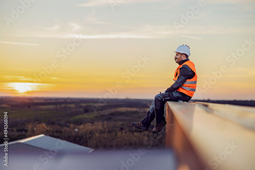 A constructor sitting on the height and smiling. photo