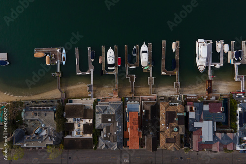 aerial view of Boats anchored on private docks in Newport Bay leading to beach houses in Newport Beach California
