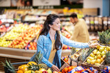 A woman choosing fruits at the supermarket.