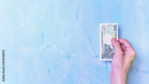 Wallpaper Mural Indonesian Rupiah the official currency of Indonesia. Man's hand is making a payment. Business Loan Income Money Investment Economy Loan Income and Finance Concept Uang 500 Rupiah. Prosperity Concept. Torontodigital.ca