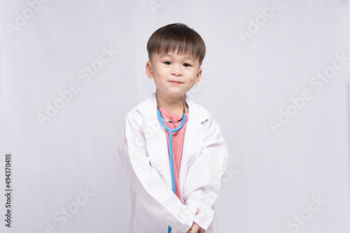boy wearing a doctor's suit with a medical stethoscope on a white background. Preschool children pretend to be a pediatrician. Childhood dream of becoming a doctor