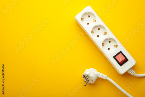 Foto Electric white portable socket on yellow background