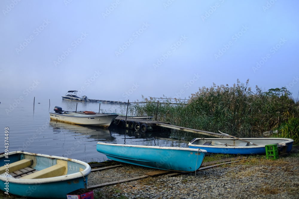 Beautiful scenery of Lake Kawaguchiko, Japan with blue boats foreground. Boats on shore of Lake Kawaguchi in autumn. Kawaguchi is second largest of famous Fuji Five Lakes Beautiful scenery of Lake Kawaguchiko, Japan with blue boats foreground. Boats on shore of Lake Kawaguchi in autumn. Kawaguchi is second largest of famous Fuji Five Lakes