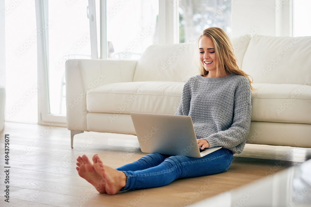 Finding a comfy place to blog. Full length shot of an attractive young woman using her laptop while chilling at home. Finding a comfy place to blog. Full length shot of an attractive young woman using her laptop while chilling at home.