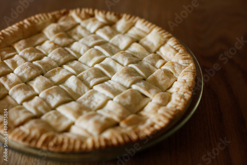 Close-up photo of homemade apple pie on a wooden table. 