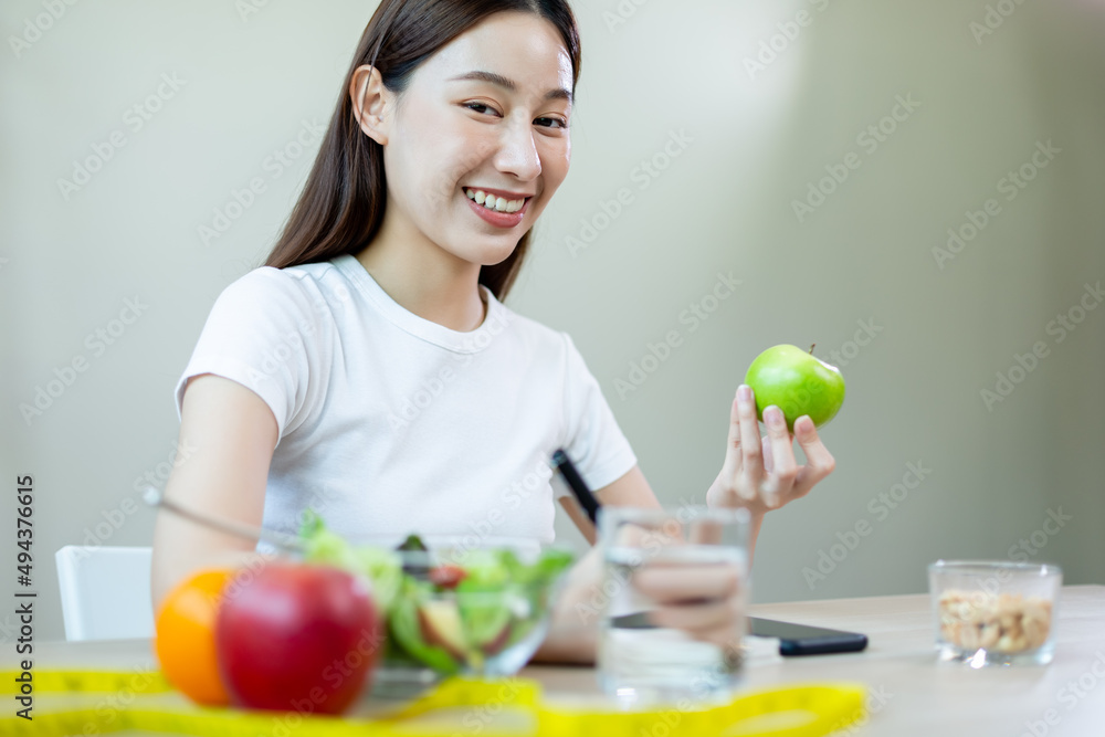 happy females smiling holding apple take note of diet day weight counting calories. eating and health care concept. happy females smiling holding apple take note of diet day weight counting calories. eating and health care concept.