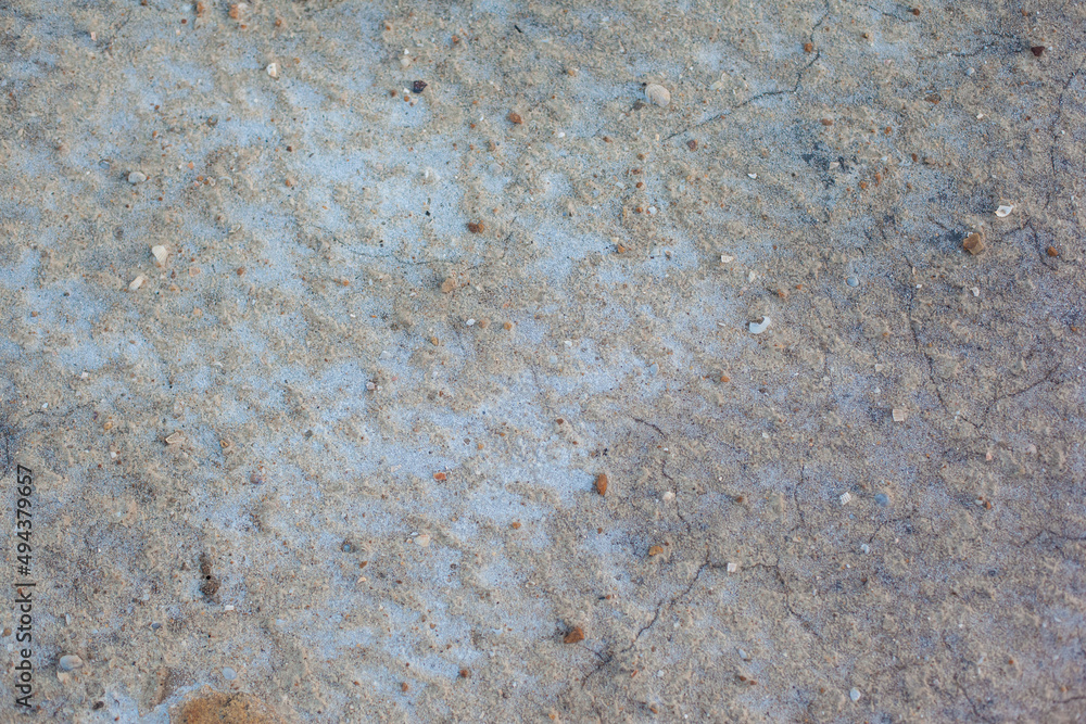 Texture of the dried earth. Gray background with cracks and hollows. Drought and lack of moisture in the soil. The consequences of abnormal heat. Environmental disaster. Global warming.