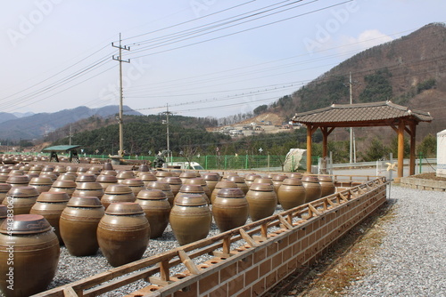 Traditional Korean ceramic preservation jars in yard, near moutains