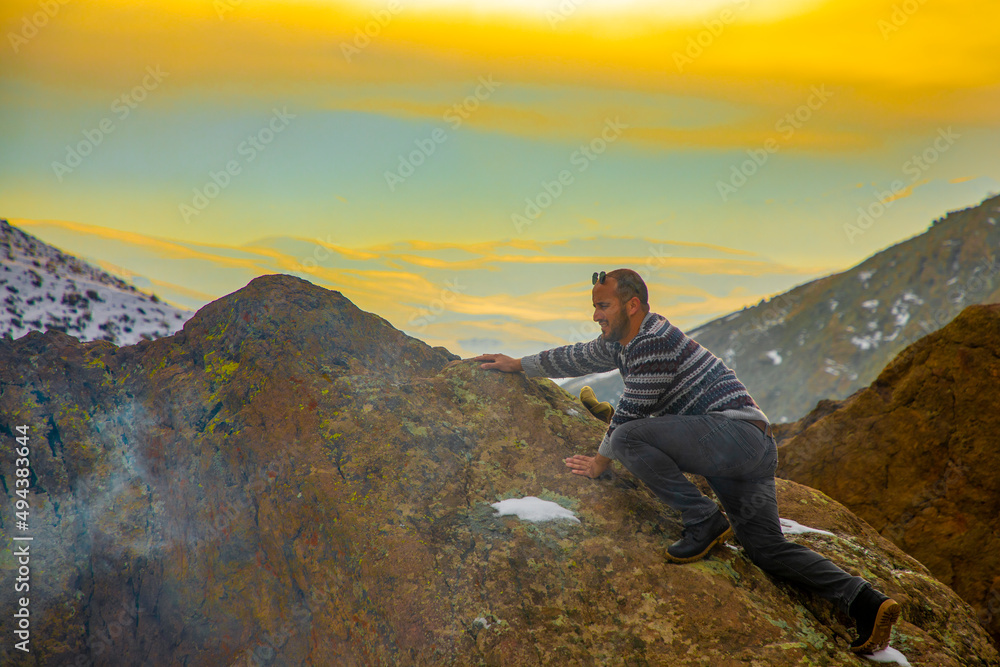 Naklejka premium A man doing mountain sports at sunset