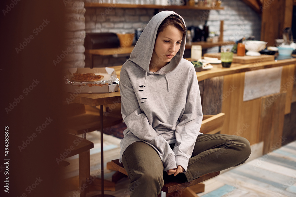 Εκτύπωση καμβά Young desperate woman in hooded shirt thinking of her problems at home
