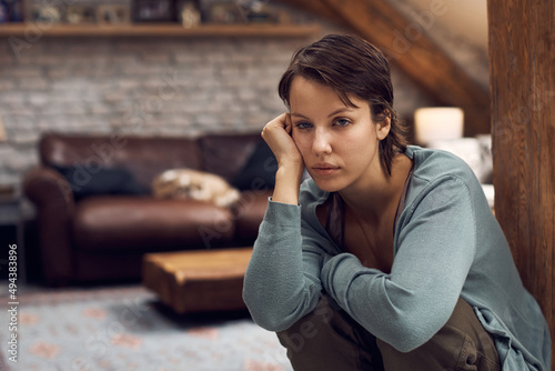 Young woman suffering from depression while being alone at home.