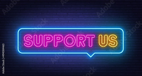 Support Us neon sign in the speech bubble on brick wall background.
