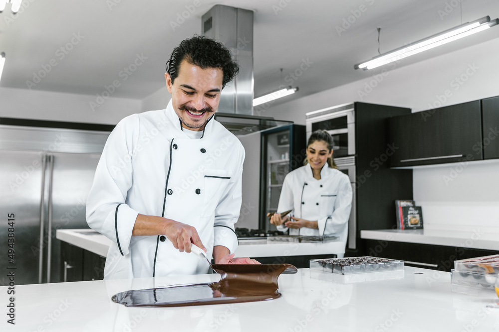 hispanic man pastry chef wearing uniform in process of preparing delicious mexican sweets chocolates at kitchen in Mexico Latin America hispanic man pastry chef wearing uniform in process of preparing delicious mexican sweets chocolates at kitchen in Mexico Latin America
