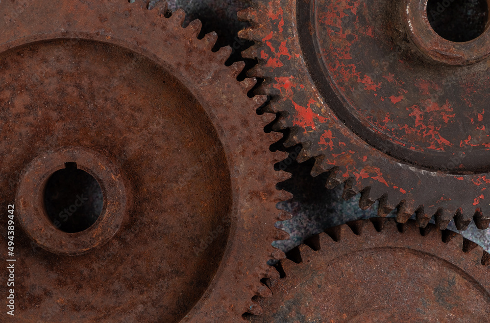 Parts of the old mechanism are metal gears covered with rust and paint on a textured background close-up. Technical concept with copy space, horizontal orientation, top view