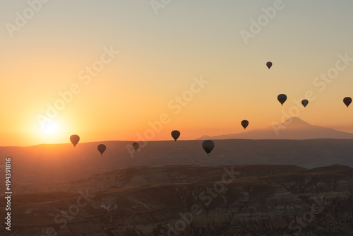Hot air balloons in the sky during sunrise. Travel, dreams come true concept. Flying over the valley in Goreme, Cappadocia, Turkey