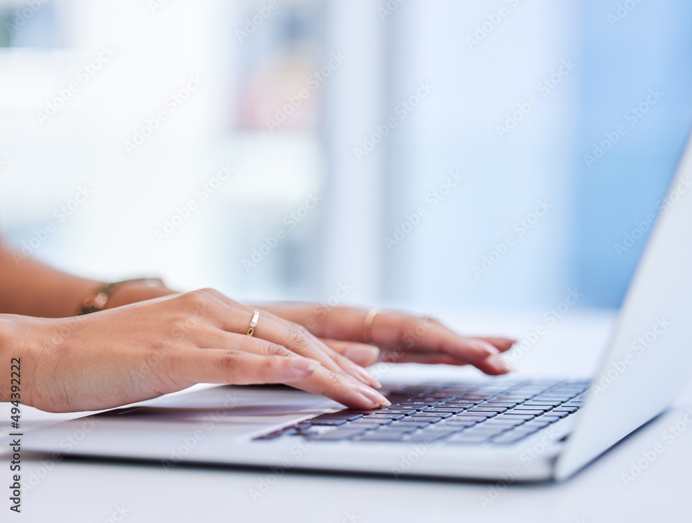 Shes got reports to finish. Cropped shot of an unrecognizable businesswoman working on her laptop while sitting in the office. Shes got reports to finish. Cropped shot of an unrecognizable businesswoman working on her laptop while sitting in the office.