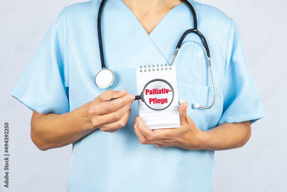 Pflegekraft oder Krankenschwester mit einer Lupe die auf Palliativ Pflege zeigt Pflegekraft oder Krankenschwester mit einer Lupe die auf Palliativ Pflege zeigt