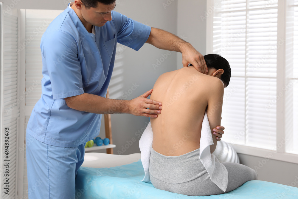 Obraz premium Orthopedist examining woman's back in clinic. Scoliosis treatment