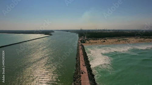 Aerial view of long breakwater of Tampico beach with walking people