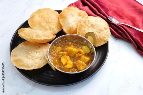 Indian cuisine - Puri Bhaji. It is a traditional breakfast dish in North India. Puri is a deep fried bread made from whole wheat flour and Served with spicy Potato curry called bhaji or alu ki sabji.