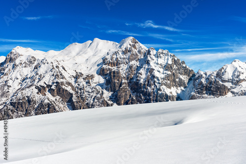 Snow capped mountain peaks in Italian Alps. Mountain range of Monte Carega (Small Dolomites) in winter, and Lessinia Plateau (Altopiano della Lessinia). Veneto and Trentino Alto Adige, Italy, Europe.