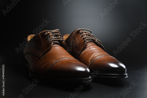 Photo of dark brown shoes on black background