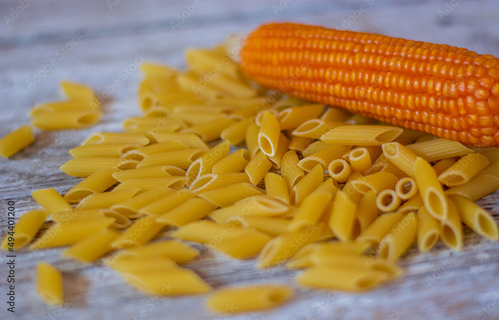 penne di pasta italiana e una pannocchia di grano maturo penne di pasta italiana e una pannocchia di grano maturo