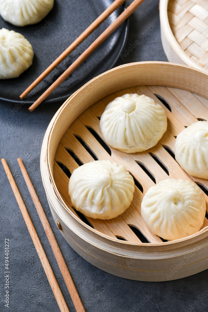 Bamboo steamers with tasty baozi dumplings, chopsticks and bowl of sauce, top view. chinese food, taiwanese food