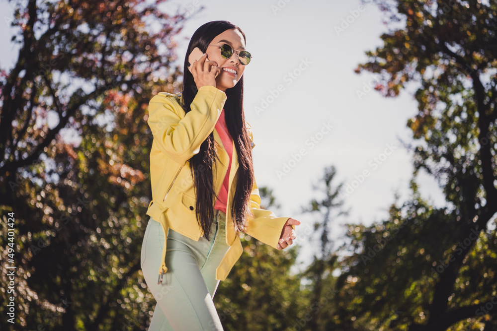 Profile portrait of charming positive lady step go say tell telephone wear yellow leather sunny weather outside Profile portrait of charming positive lady step go say tell telephone wear yellow leather sunny weather outside