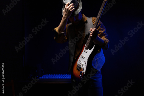 Man playing electric guitar. Musician at record studio holding electric guitar