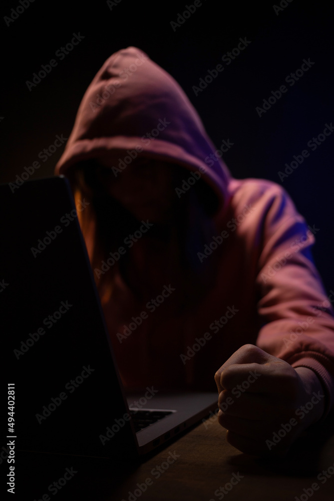Hacker woman working laptop computer. Hacker attack in dark room Hacker woman working laptop computer. Hacker attack in dark room