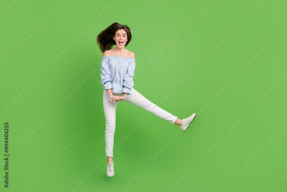 Full size photo of sweet ecstatic girl jumping playing fool relaxing on summer holiday isolated on green color background Full size photo of sweet ecstatic girl jumping playing fool relaxing on summer holiday isolated on green color background
