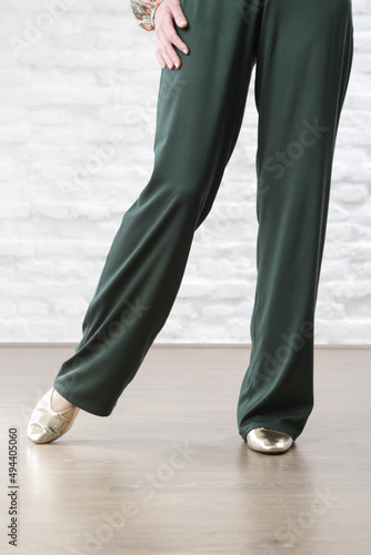 Female model wearing linen pine green casual trousers. Studio shot.