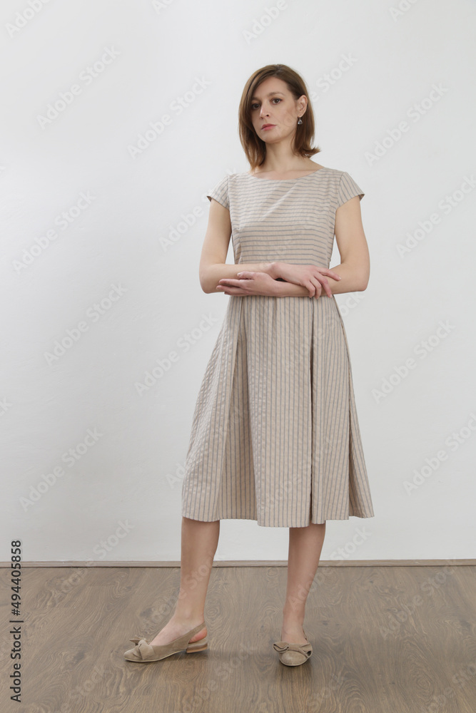 Studio shot of woman in striped cotton summer dress. Studio shot of woman in striped cotton summer dress.