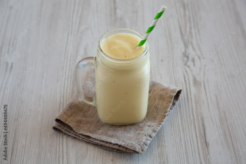 Homemade Pineapple Mango Banana Smoothie in a Glass Jar, low angle view. Homemade Pineapple Mango Banana Smoothie in a Glass Jar, low angle view.