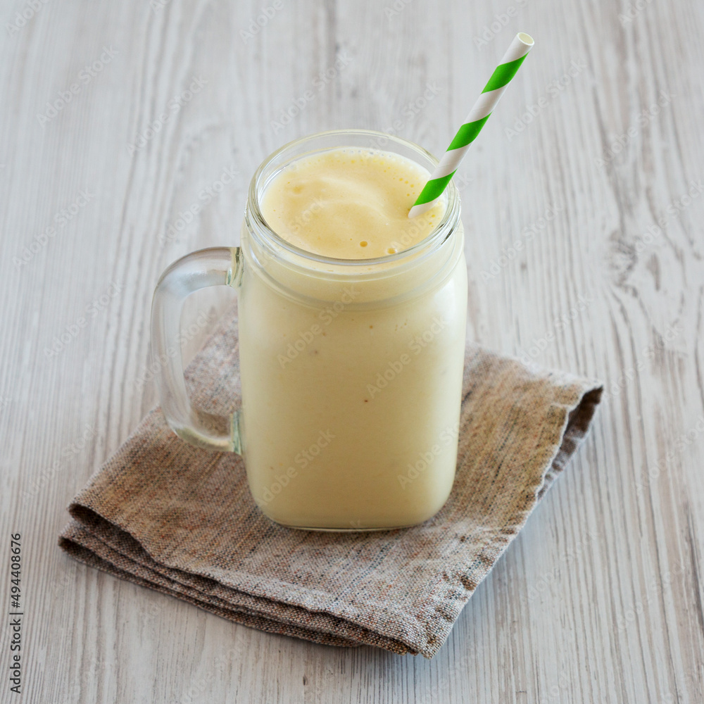 Homemade Pineapple Mango Banana Smoothie in a Glass Jar, side view. Homemade Pineapple Mango Banana Smoothie in a Glass Jar, side view.