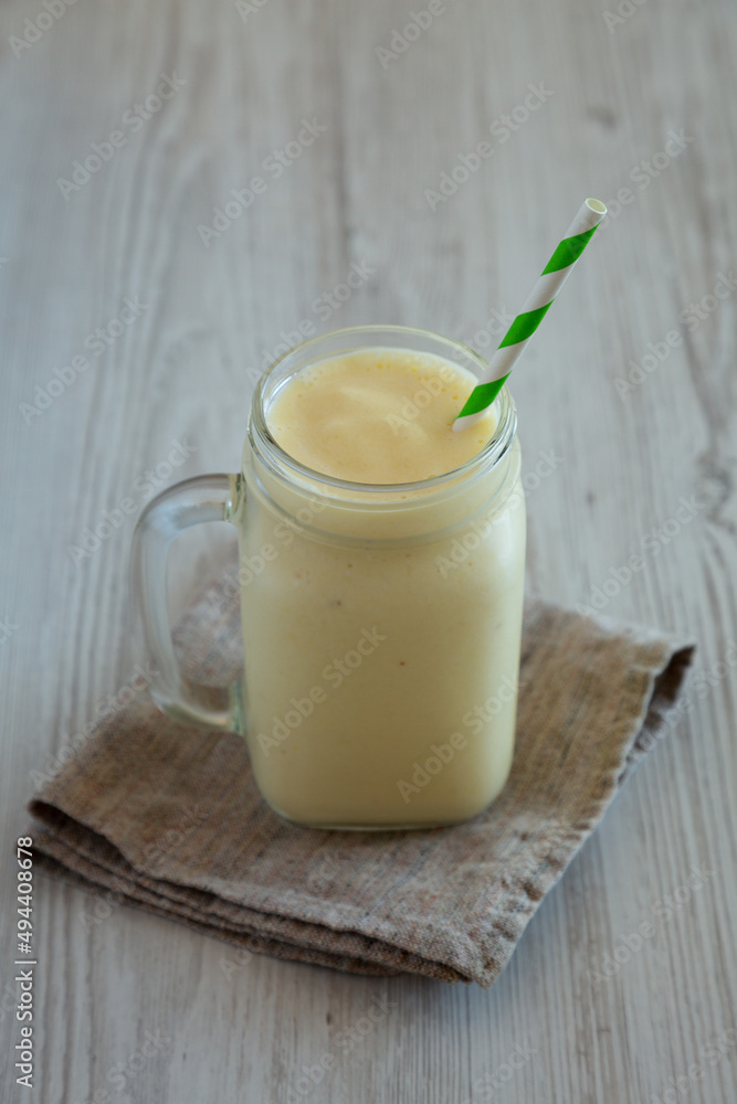 Homemade Pineapple Mango Banana Smoothie in a Glass Jar, side view. Homemade Pineapple Mango Banana Smoothie in a Glass Jar, side view.