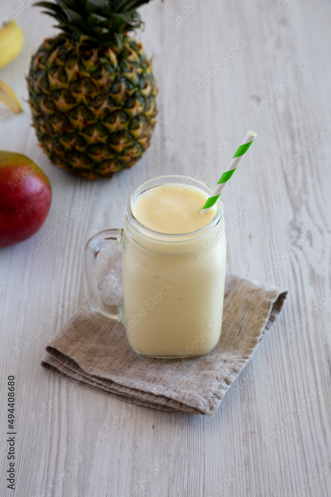 Homemade Pineapple Mango Banana Smoothie in a Glass Jar, side view. Homemade Pineapple Mango Banana Smoothie in a Glass Jar, side view.