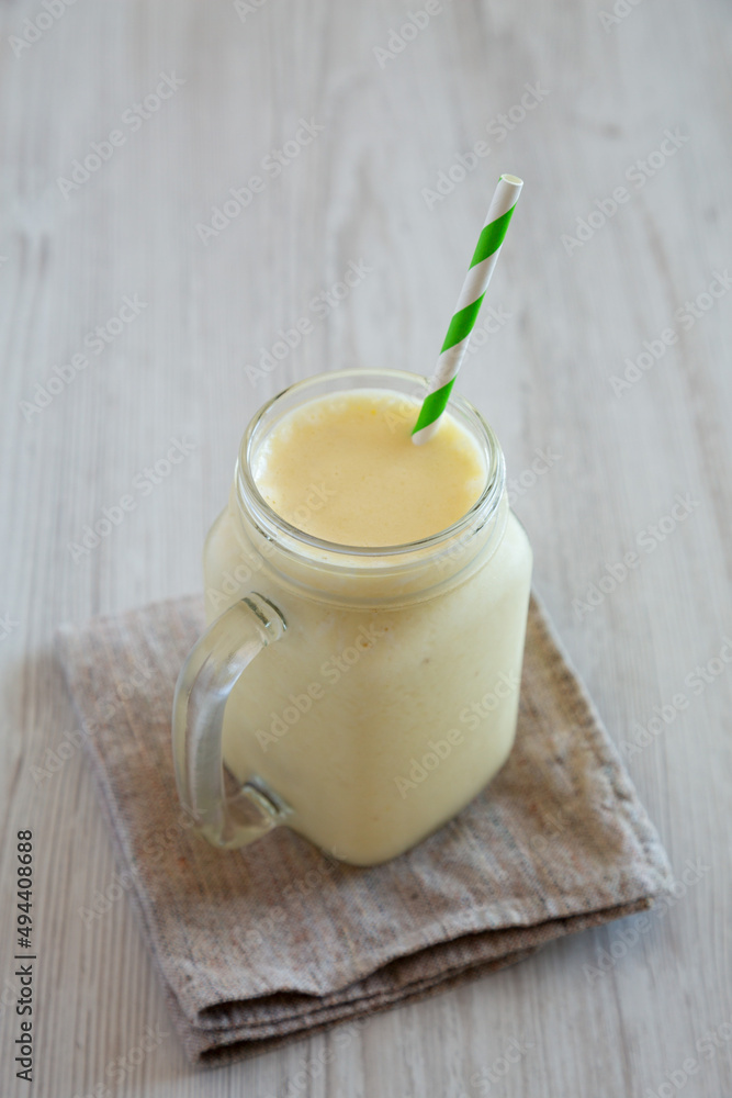 Homemade Pineapple Mango Banana Smoothie in a Glass Jar, side view. Homemade Pineapple Mango Banana Smoothie in a Glass Jar, side view.