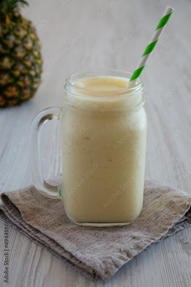 Homemade Pineapple Mango Banana Smoothie in a Glass Jar, side view. Homemade Pineapple Mango Banana Smoothie in a Glass Jar, side view.
