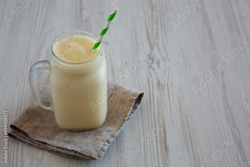 Homemade Pineapple Mango Banana Smoothie in a Glass Jar, side view. Copy space.