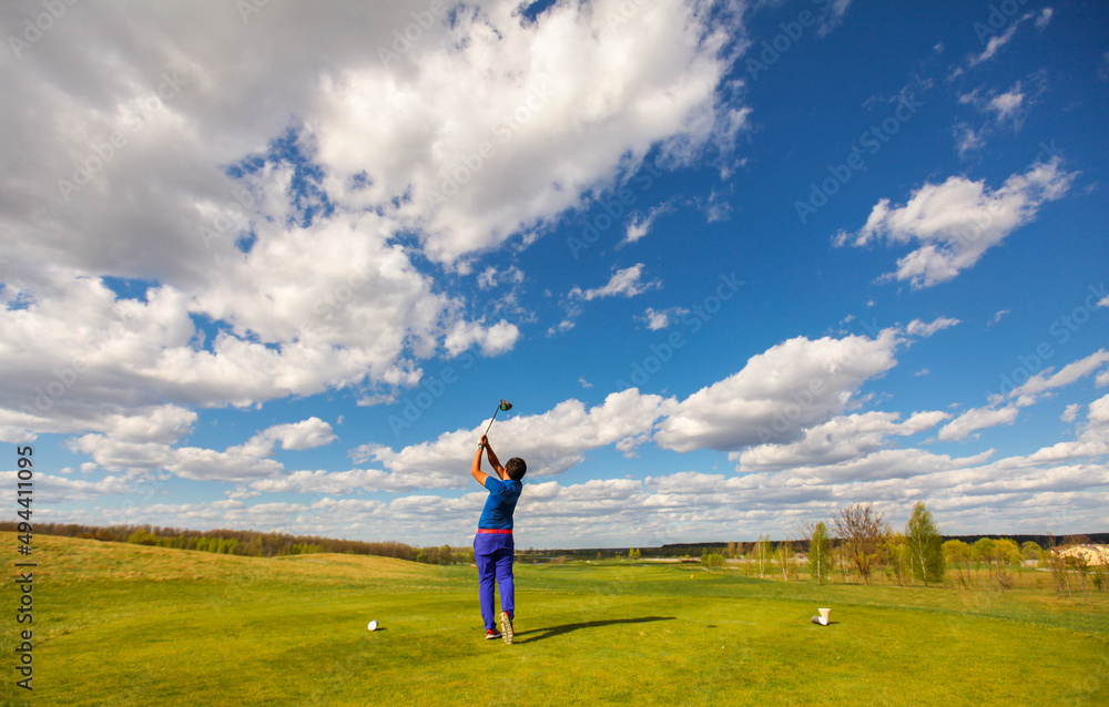 Man golf player teeing off the ball, view from behind. Space for text.
Sport playground for golf concept - wide landscape as background for your lettering about golf playing. Royal sport.
