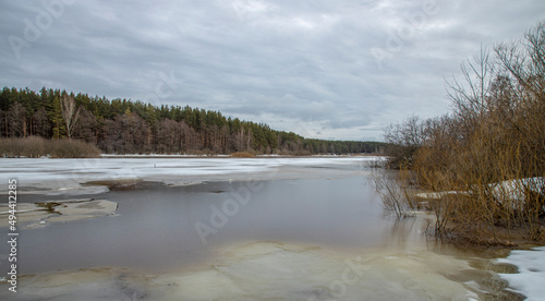 Rural landscape, early spring. European landscape in March: ice melts on the river.