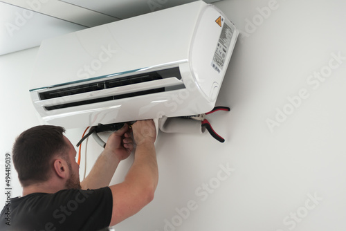 the worker connecting a new air conditioner unit