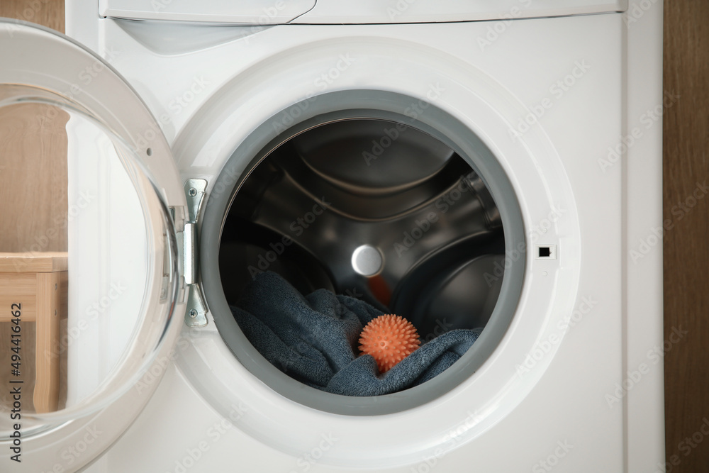 Dryer ball and towel in washing machine, closeup Dryer ball and towel in washing machine, closeup