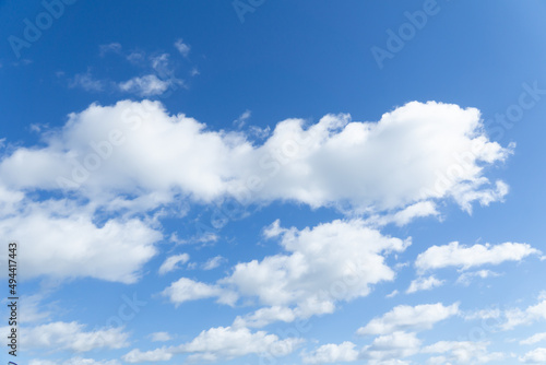 Blurred white clouds against the blue sky. Heavenly natural background. Clouds run across the sky.
